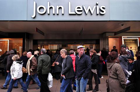 Shoppers walk past a John Lewis department store